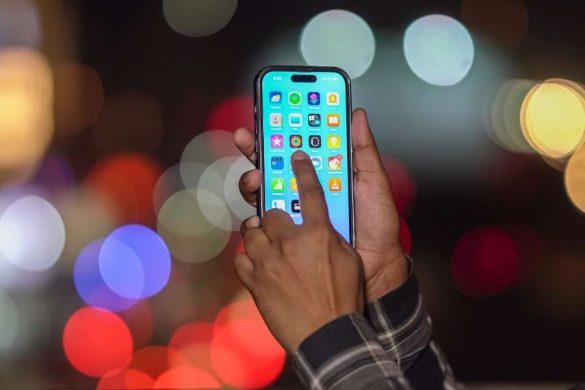 Une personne utilise une application mobile IA sur son smartphone en ville la nuit.